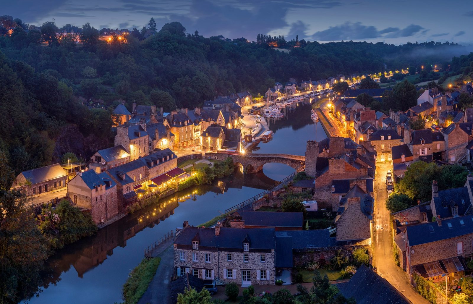 A medieval French riverside town at dusk